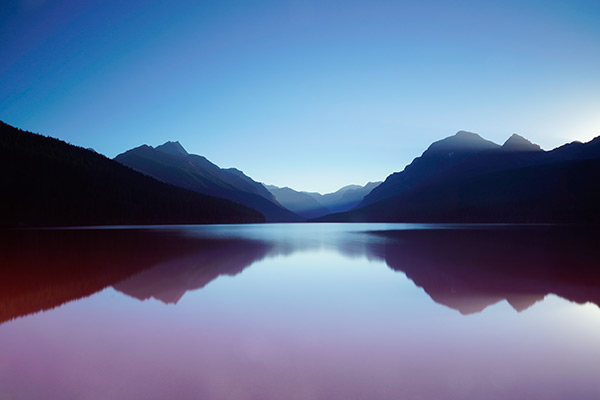 Peaceful lake with mountains at sunset