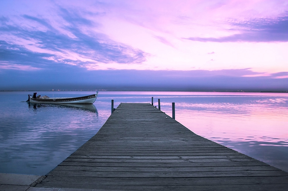 Twilight sea with water jetty and boat